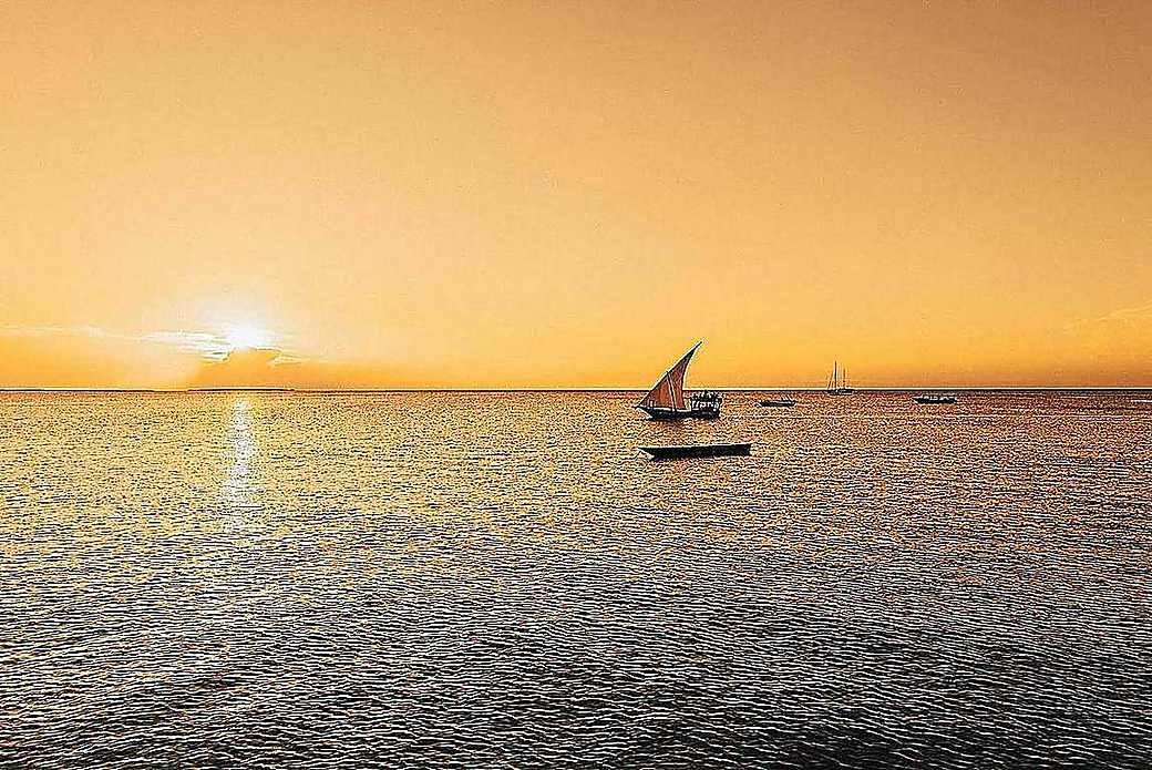 Traditional dhow sailing at sunset off Zanzibar